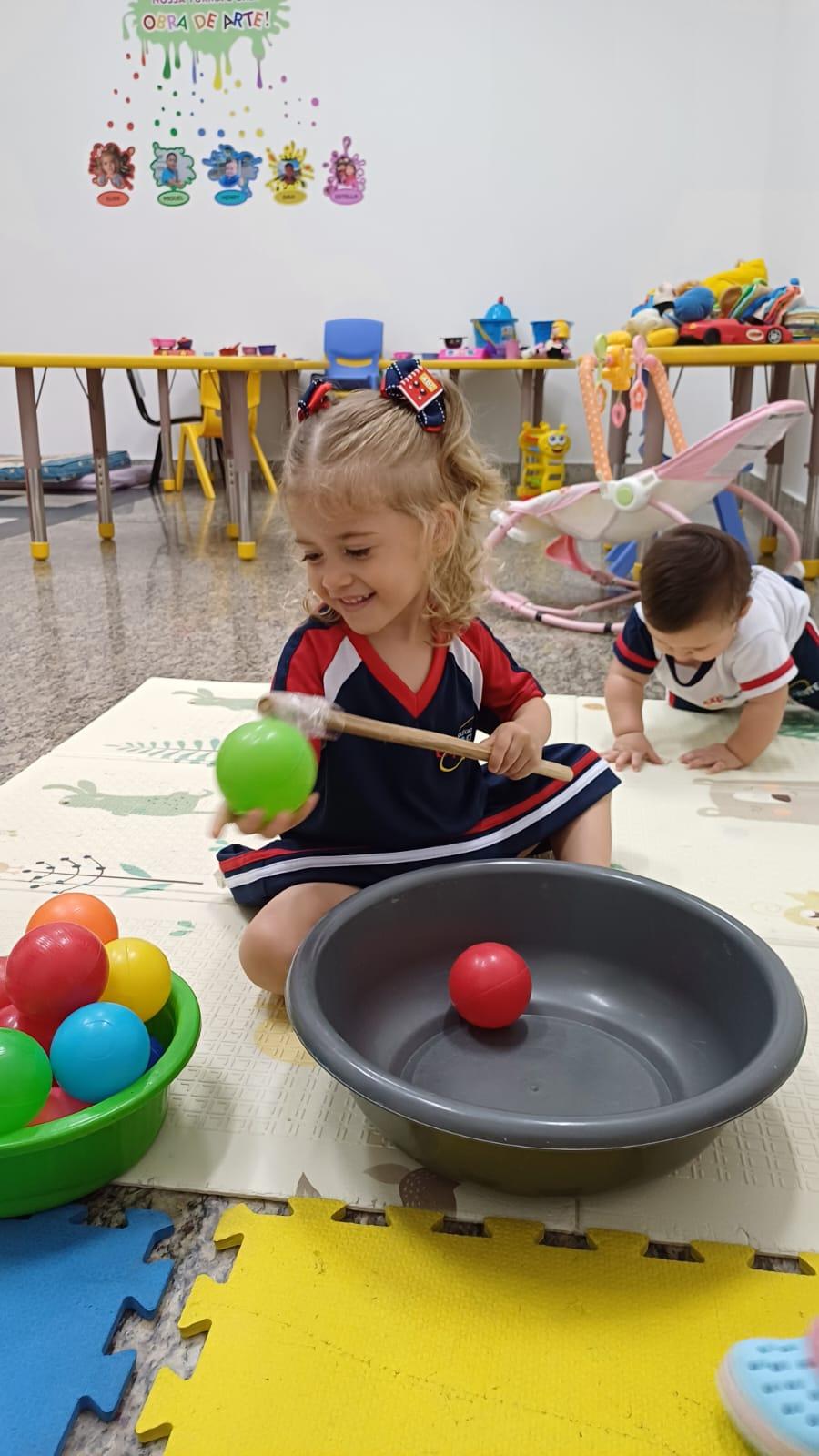 Pescar bolinhas e colocar em outra vasilha. Desenvolve a atenção,  concentração, coordenação motora e prazer.